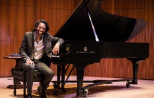 Photo of performer on stage with piano