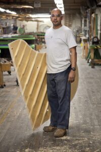 The Steinway craftsman known as the "bellyman" with a soundboard