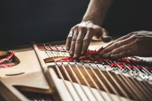 Steinway craftsperson working on piano strings