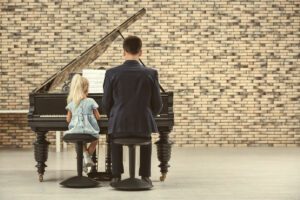 Young piano student with teacher